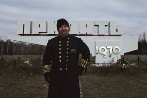 Standing in front of the Pripyat city limits sign. That one button is hard to get in the cold, don't hassle me. (Photo by Robyn von Swank, 2016)
